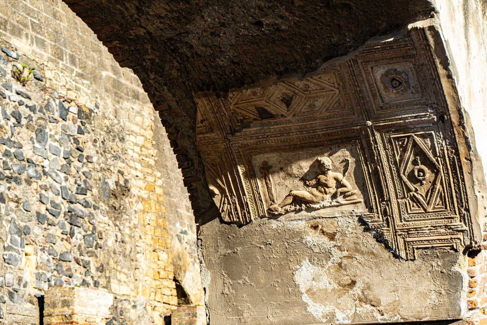 Detailed relief in Ercolano showcases Roman artistry and architectural detail.