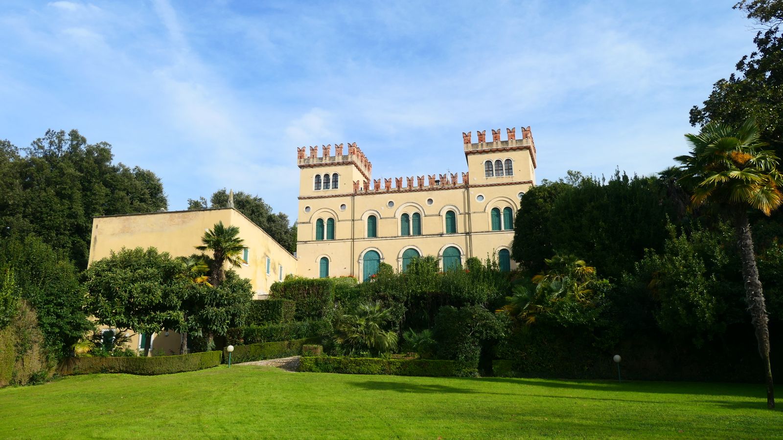 A captivating view of an Italian mansion surrounded by lush gardens in Lazise, Veneto.