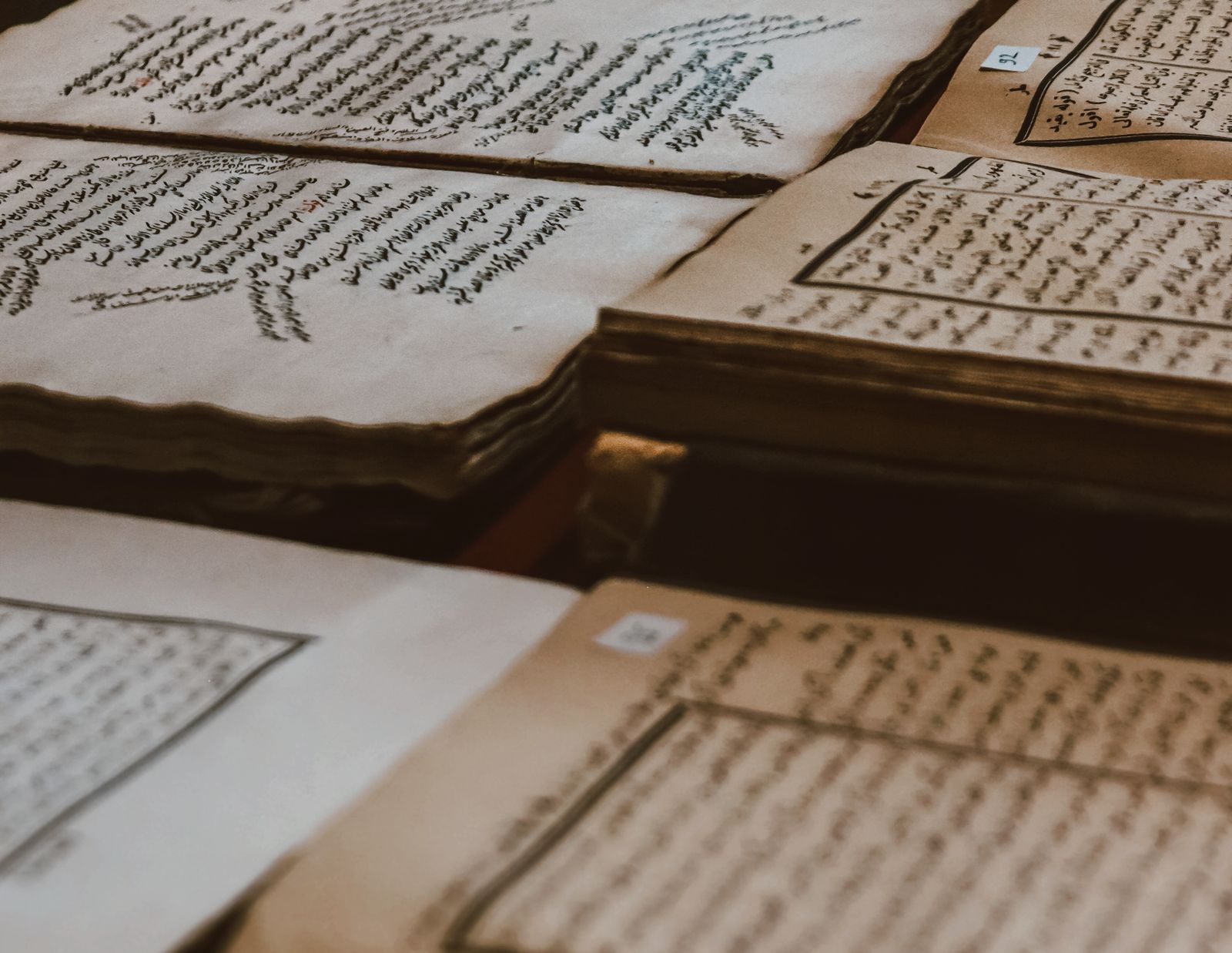 A collection of ancient manuscripts featuring Arabic script, showcasing historical texts on aged paper.